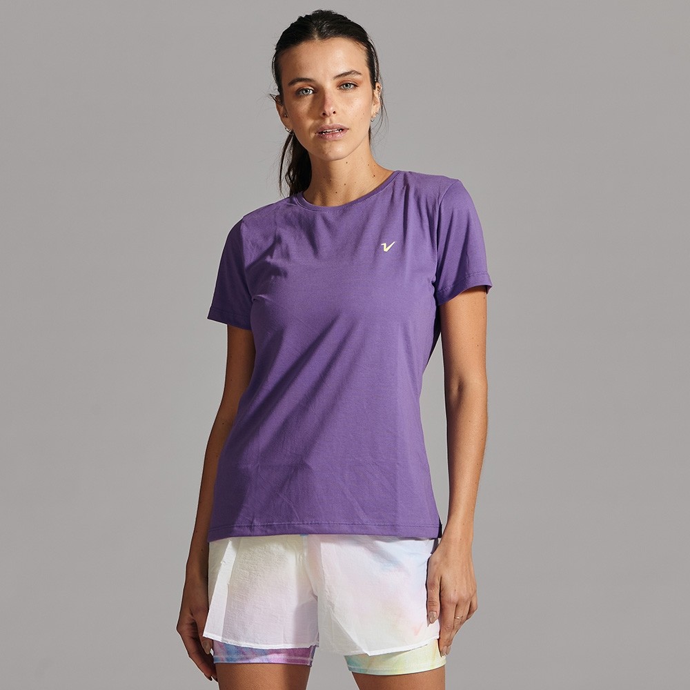 Deportista en camiseta y pantalones cortos sobre fondo violeta